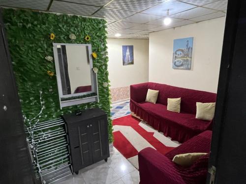 a living room with a red couch and a mirror at Holiday Home in Ajman