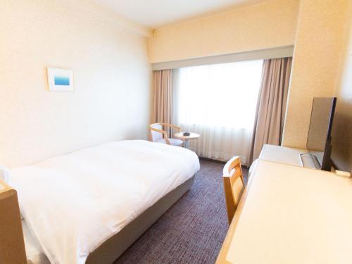 a hotel room with a bed and a window at Toyama Chitetsu Hotel in Toyama