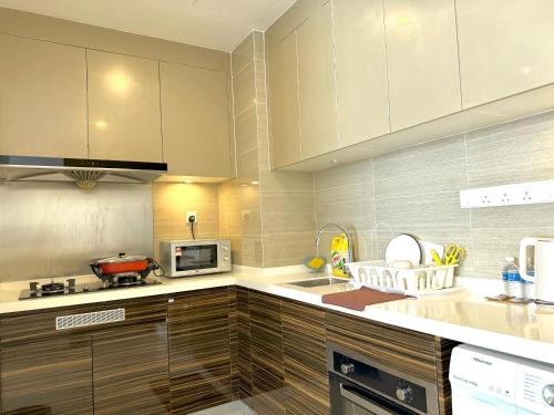 a kitchen with white cabinets and a counter top at R&F Seine Region in Johor Bahru