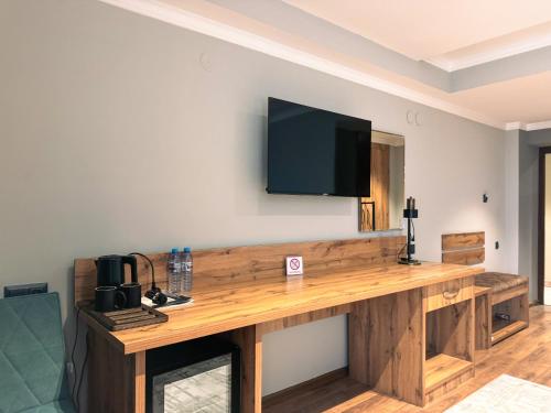 a large wooden table with a television on a wall at Ziyorat Luxury Hotel in Fergana