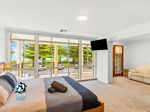 a bedroom with a bed and a large window at Luxury Ocean Front 3BR Home in Central Victor in Victor Harbor