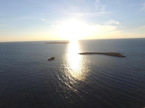an island in the ocean with the sun in the sky at Corte Moline in Gallipoli