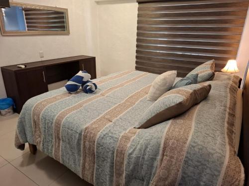 a teddy bear sitting on top of a bed at Condominio Xaman Ha 7107 in Playa del Carmen