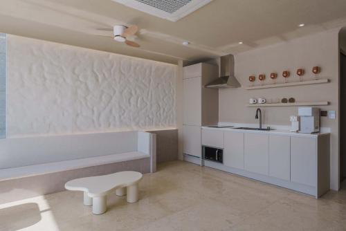 a white kitchen with a bench and a sink at Meomulda Gwangalli Gamsung in Busan