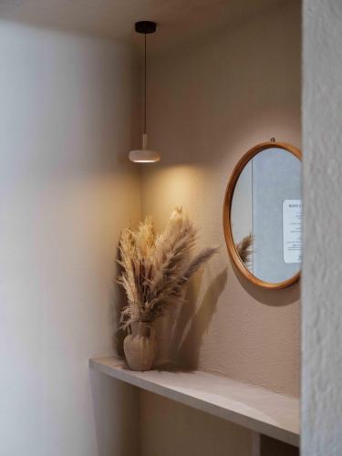 a mirror and a plant on a shelf in a room at Meomulda Gwangalli Gamsung in Busan