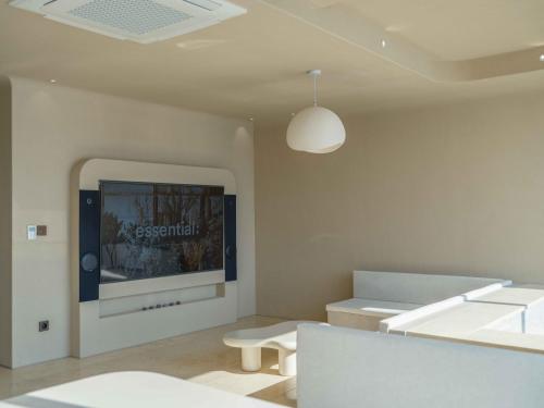 a room with white furniture and a tv on the wall at Meomulda Gwangalli Gamsung in Busan