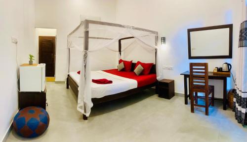 a bedroom with a canopy bed with a soccer ball at Tropicana Home Stay in Arugam Bay