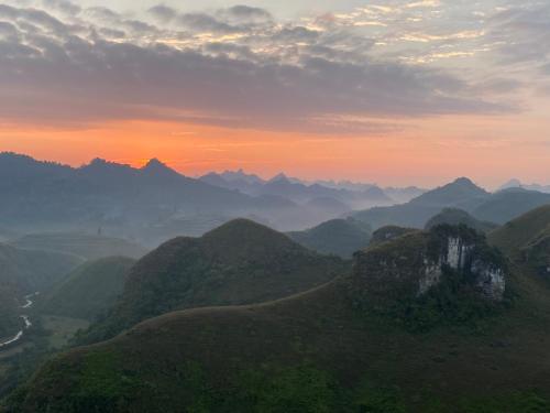 a view of a mountain range with the sun setting at Ba Quáng Panorama in Hạ Lang