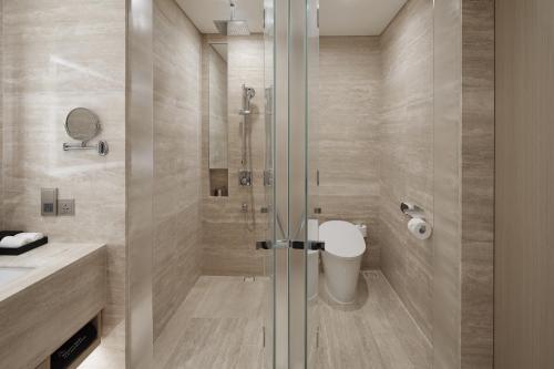 a bathroom with a shower and a toilet at Landing Jeju Shinhwa World Hotel in Seogwipo