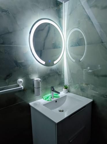 a bathroom with a sink and a mirror at Moldo Residence in Ocna-Mureşului