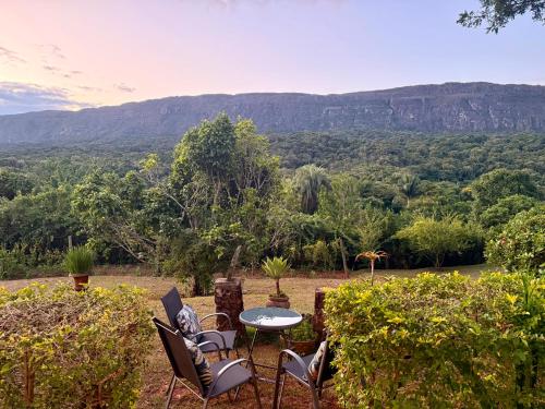 a table and chairs with a view of a mountain at Segredo da Serra Guest House in Tiradentes