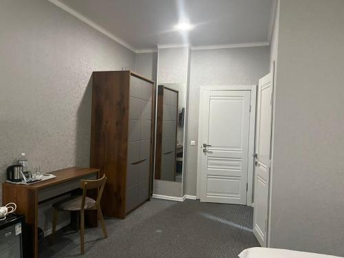 a room with a desk and a bed and a mirror at Hotel "CONTINENT" halal in Karagandy