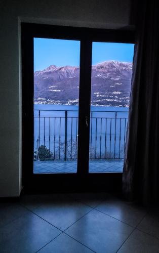 a window with a view of the water and mountains at La Mansarda sul lago in Bellano