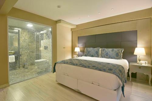 a bedroom with a large bed and a shower at Perada Suite & Room in Istanbul