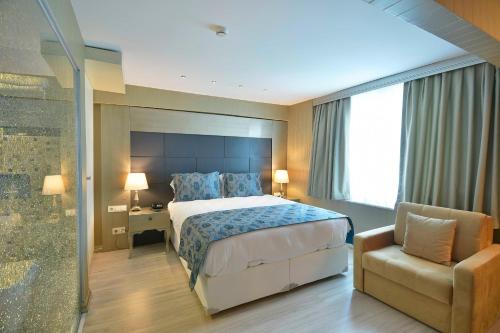 a bedroom with a bed and a chair and a window at Perada Suite & Room in Istanbul