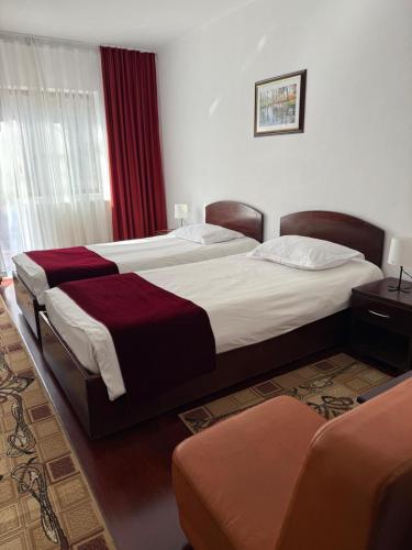 a hotel room with two beds and a couch at Hotel Ciric in Iaşi