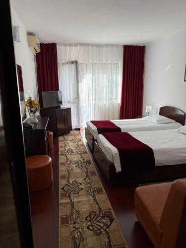 a hotel room with two beds and a window at Hotel Ciric in Iaşi