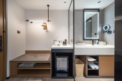 un baño con lavabo y espejo en Atour Hotel Guangzhou Zhongcun Hanxi Changlong Metro Station, en Guangzhou
