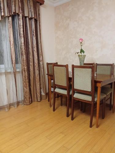 a dining room with a table and chairs and curtains at Sirik in Yerevan