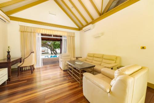 a living room with a couch and a table at Sun Siyam Olhuveli in South Male Atoll