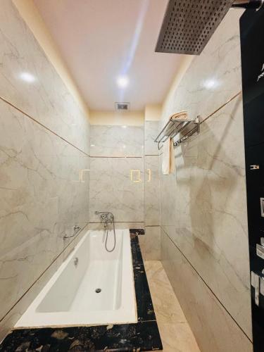 a bathroom with a tub and a shower at KashVi Hotels in Varanasi