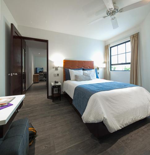 a bedroom with a large bed and a couch at FlowSuites Polanco in Mexico City