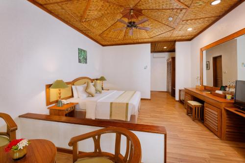 a hotel room with a bed and a television at Bandos Maldives in North Male Atoll