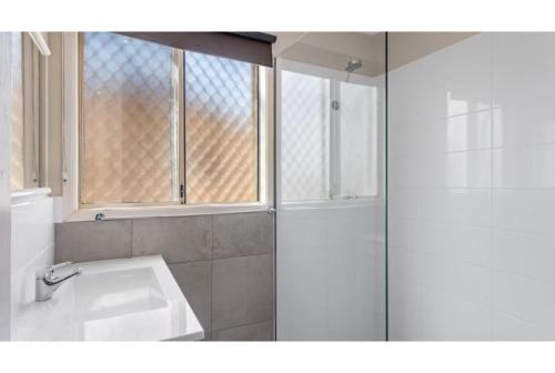a white bathroom with a shower and a sink at Discovery Parks - Port Hedland in Port Hedland