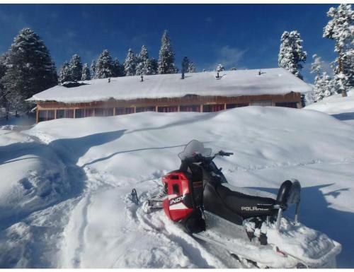 a snowmobile parked in the snow in front of a building at Roseland Cottage, Gulmarg in Gulmarg