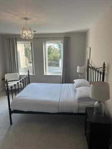 a bedroom with a large white bed and a window at Luxury Sunrise Guest House County Down in Killyleagh