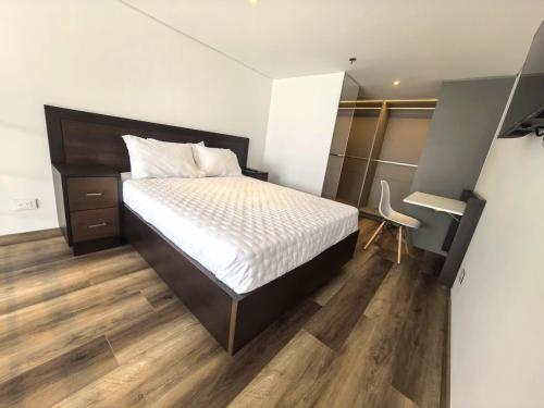 a bedroom with a bed and a desk in it at Novedoso apartaestudio en Chico in Bogotá