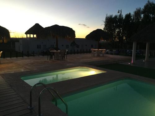 a swimming pool with a sunset in the background at Catorce Capital A una HORA de Real de Catorce in Estación Catorce