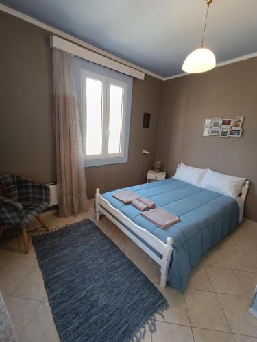 a bedroom with a blue bed and a window at PENELOPE'S STREET OLD HOUSE in Lefkada