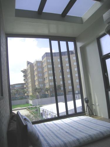 a bedroom with a large window in a building at Penghu 123 V-Stone in Magong