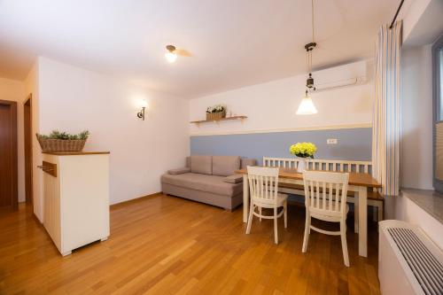 a living room with a table and chairs and a couch at Lakeside Apartments Bled in Bled