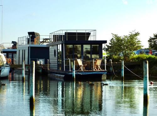 a house boat docked at a dock in the water at Floating freedom by the Dodekalitten in Torrig