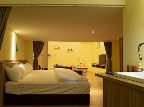 a bedroom with a bed and a bathroom with a sink at Old Street Seaview Homestay in Jiufen