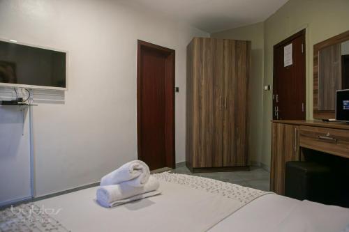 a hotel room with a bed with towels on it at Byblos Hotel-Sky Osu in Accra