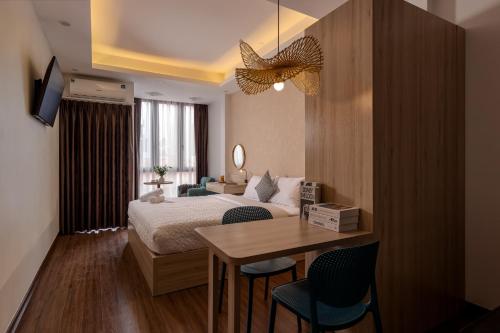 a bedroom with a bed and a table with chairs at The Urban Tranquil in Hanoi