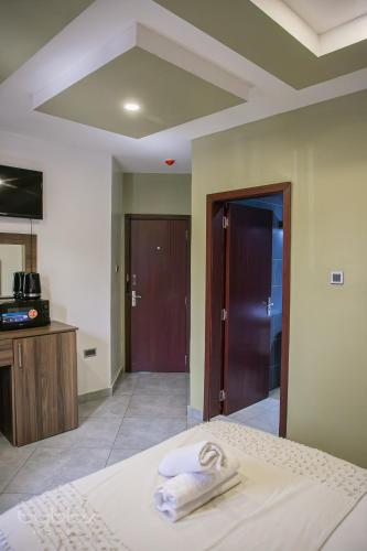 a bedroom with a bed with a towel on it at Byblos Hotel-Sky Osu in Accra