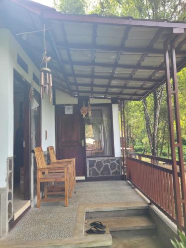 a porch with a wooden pergola and a chair at D'Langun Bali in Munduk