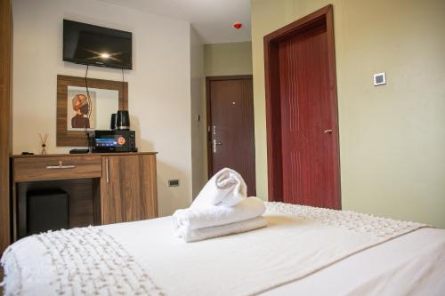 a hotel room with a bed with a towel on it at Byblos Hotel-Sky Osu in Accra