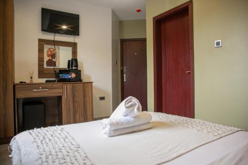 a hotel room with a bed with towels on it at Byblos Hotel-Sky Osu in Accra