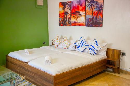 two beds in a room with a green wall at Byblos Hotel-Sky Osu in Accra