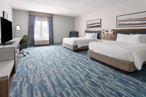 a hotel room with two beds and a flat screen tv at Hilton Garden Inn Winston-Salem/Hanes Mall in Winston-Salem