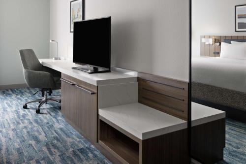 a room with a desk with a computer and a bed at Hilton Garden Inn Winston-Salem/Hanes Mall in Winston-Salem
