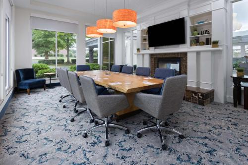 a dining room with a wooden table and chairs at Hilton Garden Inn Winston-Salem/Hanes Mall in Winston-Salem