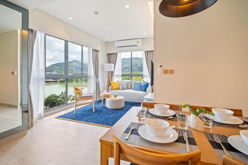a dining room with a table and a living room at Laguna Lakeside Residences by Banyan Living in Laguna Phuket