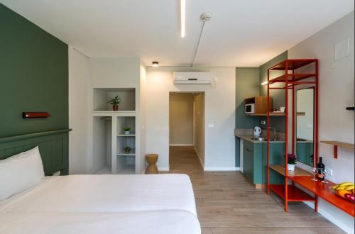 a bedroom with a white bed and a green wall at Degania Bet Kibbutz Country Lodging in Kinneret