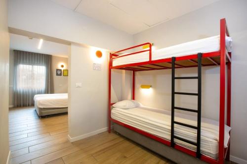 a bedroom with two bunk beds in a room at Degania Bet Kibbutz Country Lodging in Kinneret